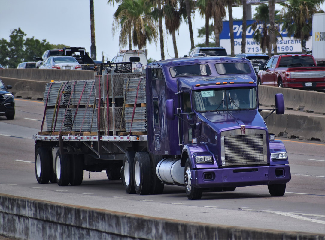 Purple commercial semi truck carrying cargo. 